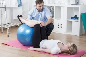 Photo of woman during rehabilitation exercising with ball